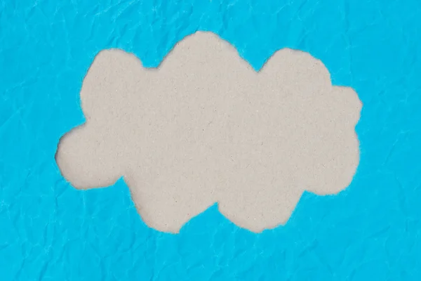 Cloud shape  hole on piece on blue paper — Stock Photo, Image