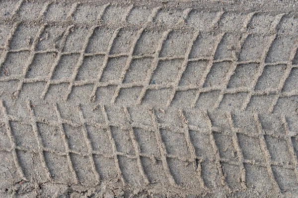 Отпечатки шин на песчаном фоне — стоковое фото