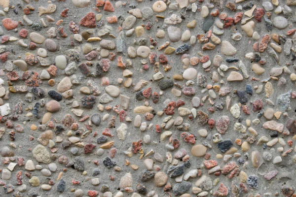Grå vägg dekorerad med färgglada stenar bakgrund textur — Stockfoto