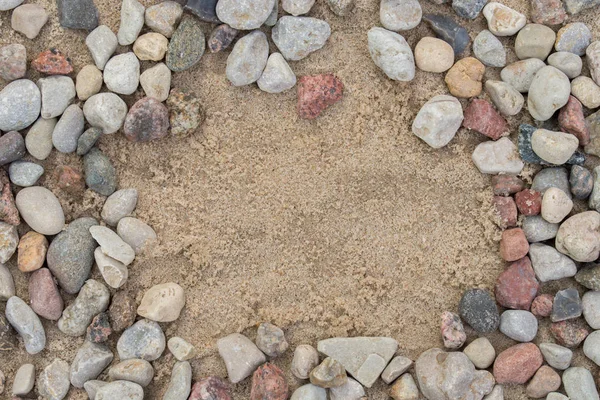 Borda feita de pedras de seixo na areia — Fotografia de Stock