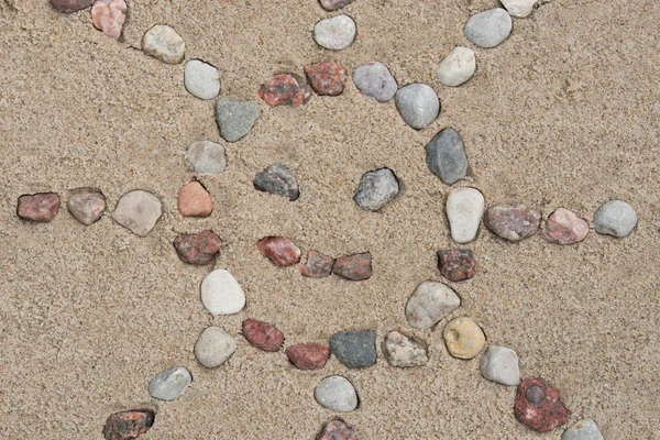 Forma de sol hecha de piedras de guijarro sobre fondo de arena —  Fotos de Stock