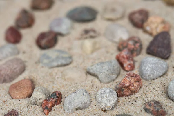 Padrão espiral feito de pebbes na areia — Fotografia de Stock