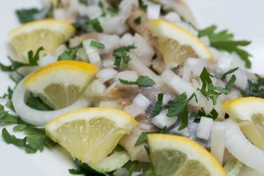 maydanoz, soğan ve limon dilimleri ile marine ringa 