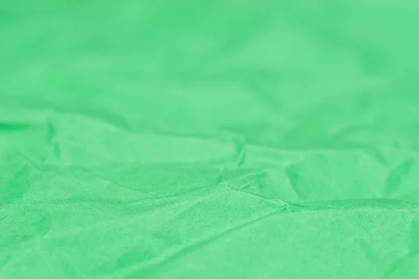 緑色の折り目付きカラーペーパーテクスチャ背景選択的フォーカス — ストック写真