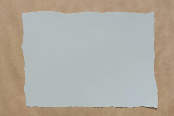 Pezzo grigio di carta strappata su carta riciclata sfondo texture — Foto Stock