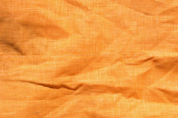 折り目付きオレンジ色の織物の背景テクスチャ — ストック写真