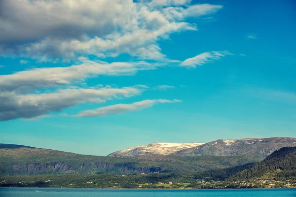 Dramatik bulutlu gökyüzü ile güzel mavi deniz. Norveç'in vahşi doğa. Ufukta Adaları