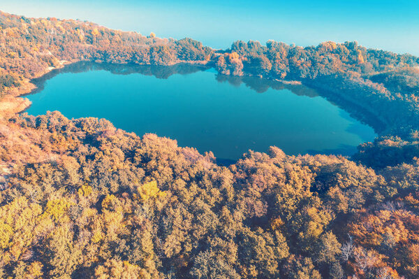 Picturesque mountain forest lake in autumn at sunrise. Lake near the sea. Beautiful wild nature. Aerial view