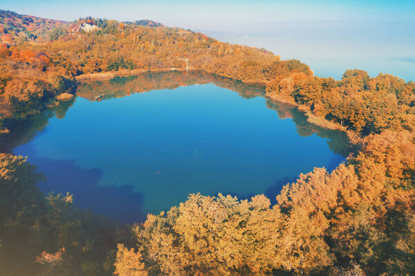 Picturesque mountain forest lake in autumn at sunrise. Lake near the sea. Beautiful wild nature. Aerial view