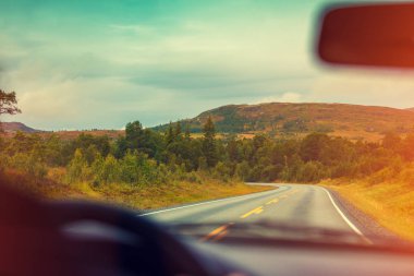 Gün batımında dağ yolda arabayı. Ön cam görüntüleyin. Norveç'in Doğa