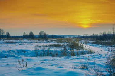 Kırsal kış manzara. Gün batımı ışıkta karlı alan