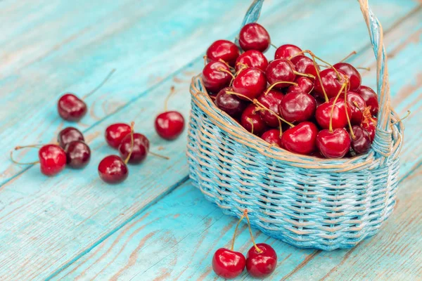 Sweet red fresh cherries in a basket on grunge wooden table