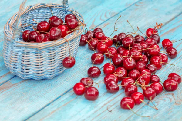 Sweet red fresh cherries in a basket on grunge wooden table