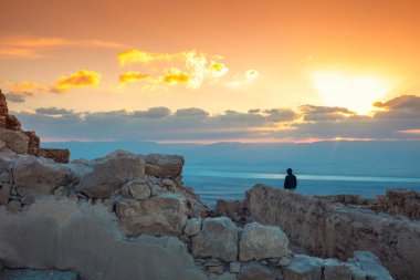 Dead Sea üzerinde güzel gündoğumu. Masada kale görünümü. Judaean Çölü 'ndeki Kral Herod sarayının Harabeleri