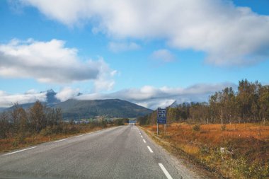 Senja adasında yolda bir araba sürüş, cam görünümü. Norveç, Avrupa