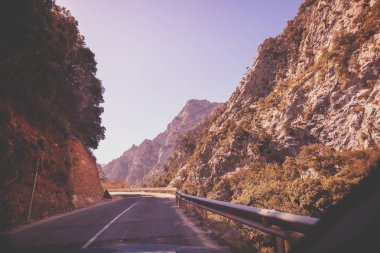 Güneşli bir günde güzel bir dağ manzarasının ön camdan görünüşü. Picos de Europa Ulusal Parkı 'ndaki dağlık viraj yolunda araba kullanmak. Cantabria, İspanya, Avrupa