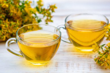 Hypericum bitkisel (Tutsan) çay ahşap grunge masada iki bardak