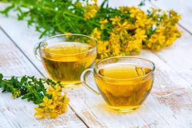 Hypericum bitkisel (Tutsan) çay ahşap grunge masada iki bardak