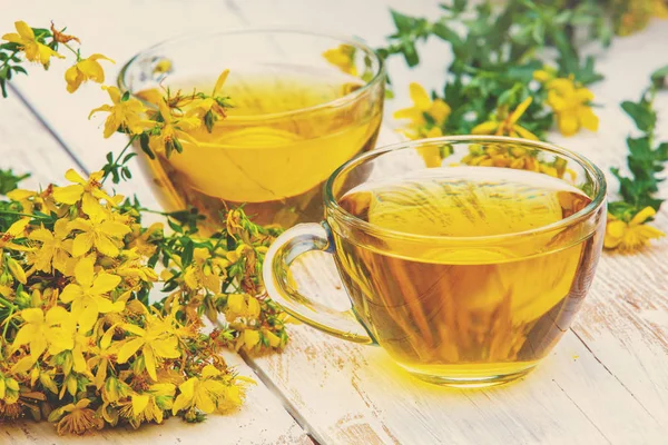 Hypericum bitkisel (Tutsan) çay ahşap grunge masada iki bardak