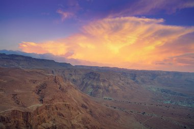 Dağ doğa manzara. Dağdan vadinin manzarası. Sabahın erken saatlerinde Judean Çölü. Dağların üzerinde güzel bir bulut. Masada kalesinin üzerinde güzel gün doğumu. İsrail.