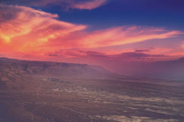Mountain desert landscape. View of the valley from the mount. Desert in the early morning. Beautiful sunrise over Masada with dramatic sky. The Judaean Desert. Landscape in Dead sea region. Nature Israel