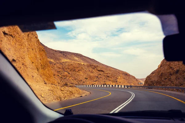在沙漠的山路上开车 通过挡风玻璃欣赏砂岩山脉 从阿拉德到死海的路以色列 — 图库照片