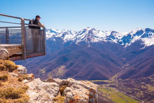 Ein Mann Steht Auf Einem Aussichtspunkt Über Einem Tal Vor lizenzfreie Stockfotos
