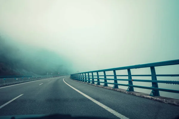 フロントガラスからの陸橋の眺め 高速道路 劇的な曇りの空と美しい霧の朝の風景 スペインのアストゥリアス州 — ストック写真