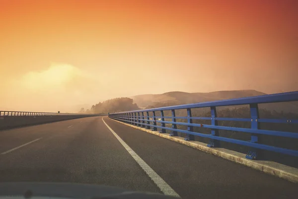 透过挡风玻璃看河上的桥 美丽的夜景 夕阳西下的高速公路 西班牙阿斯图里亚斯 — 图库照片