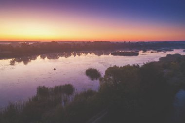Gölün üzerinde büyüleyici bir gündoğumu ve suyun üzerinde güzel bir yansıması var. Sabahın erken saatlerinde sakin bir göl. Doğa manzarası