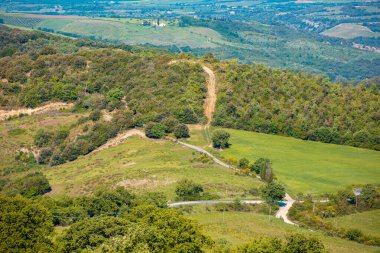 Güzel bahar manzarası. Güneşli bir günde dağlarla ve vadilerle manzara. Tuscany, İtalya 'nın yuvarlanan tepelerindeki güneşli tarlaların manzarası