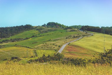 Güzel bahar manzarası. Güneşli bir günde dağlarla ve vadilerle manzara. Tuscany, İtalya 'nın yuvarlanan tepelerindeki güneşli tarlaların manzarası