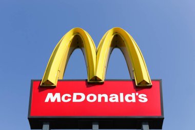 Skanderborg, Denmark - April 20, 2018:  Mc Donald's logo on a pole. McDonald's is the world's largest chain of hamburger fast food restaurants clipart