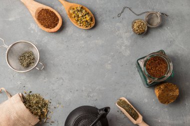 Gri arka planda tahta kaşıklı otlar.