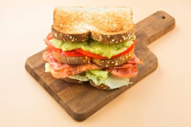 Sandviç, marul, guacamole, pastırma ve domates.