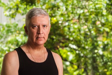 Yakışıklı orta yaş erkek açık dikey, yeşil bir arka plan.