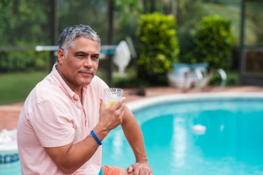Yakışıklı orta yaş İspanyol adam açık hava yaşam tarzı bir ev ortamında bir yüzme havuzu tarafından.