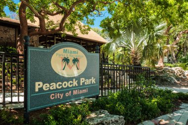 Miami, Florida - 21 Ağustos 2018: Giriş işareti için popüler bayfront trendy Coconut Grove Park'ta tavus kuşu.