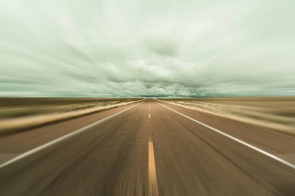 ぼかしの動きとアリゾナ州の長い砂漠の道路 — ストック写真
