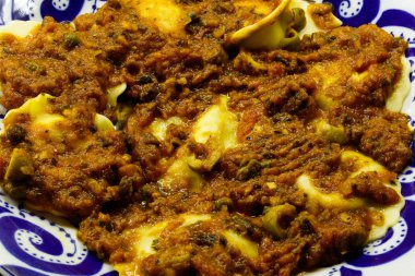 Mantarlı ravioli kırmızı sos ile bir tabak görünümünü kapat.