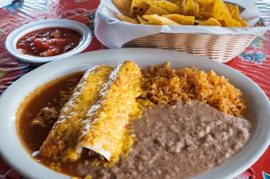 Tortilla cips, pilav, kızartılmış fasulye, börek ve enchilada ile geleneksel Meksika tarzı yemek.