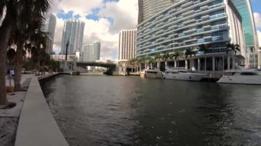 Miami, Florida ABD - 15 Şubat 2019: Hareket video lapse time tarafından modern gökdelenler normal hızda tekne ile şehir bölge boyunca Miami Nehri'nin.