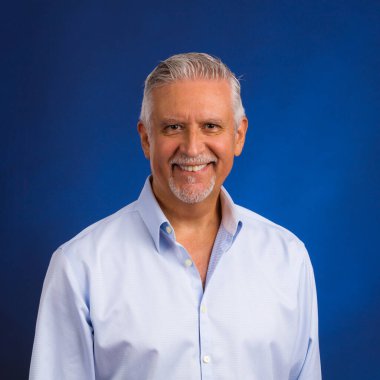 Yakışıklı, orta yaşlı, mavi arkaplanı olan bir stüdyo resmi..