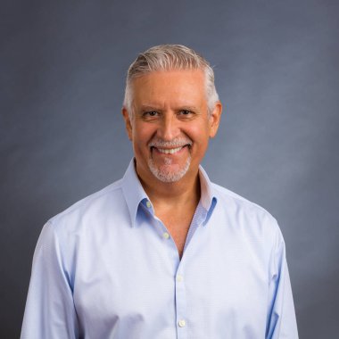 Gri bir geçmişi olan yakışıklı orta yaşlı bir erkek stüdyo resmi..