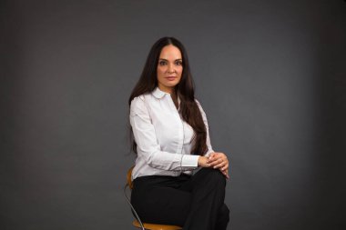 Gri arka planda güzel bir genç kadın stüdyo resmi..