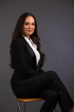 Gri arka planda güzel bir genç kadın stüdyo resmi..