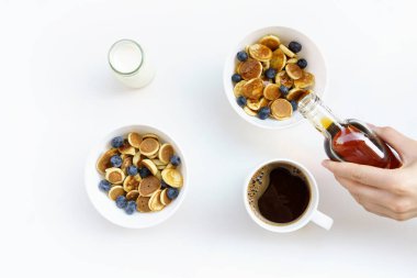 Akçaağaç pekmezli mini krep, süt ve yabanmersini ve beyaz izole edilmiş siyah kahve.