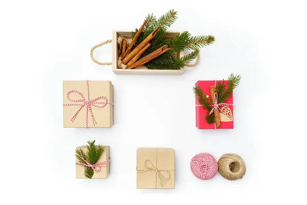 Flat lay craft boxes, rope and wooden box with cinnamon and pine tree on white