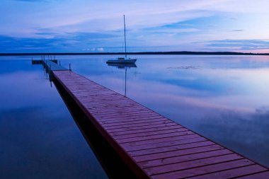 Göl kenarında, rıhtımın yanında. Akşam batımı.