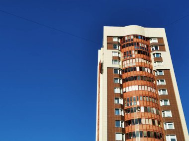 Açık gökyüzünün arka planında daireleri olan bir gökdelen..